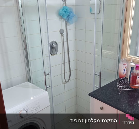 מקלחון זכוכית פינתי עם דלתות הזזה מותקן בחדר רחצה